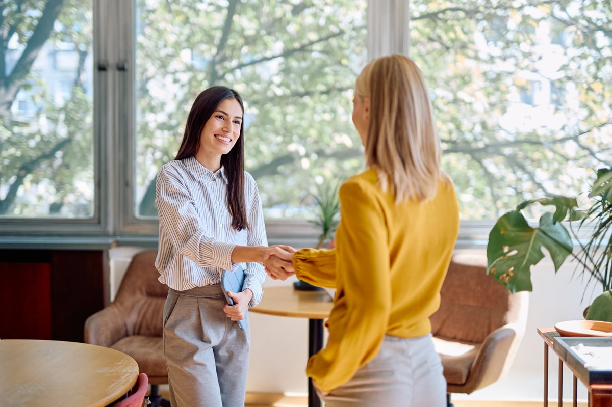 Twee professionals in gesprek tijdens een zakelijke kennismaking in een modern kantoor
